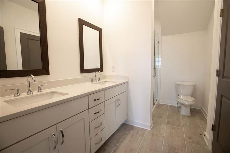 Private owners full bathroom features dual vanity with quartz countertops and walk in shower with frameless shower door *Home is Under Construction. Photos shown are from other TPG Communities to display how the home will live*