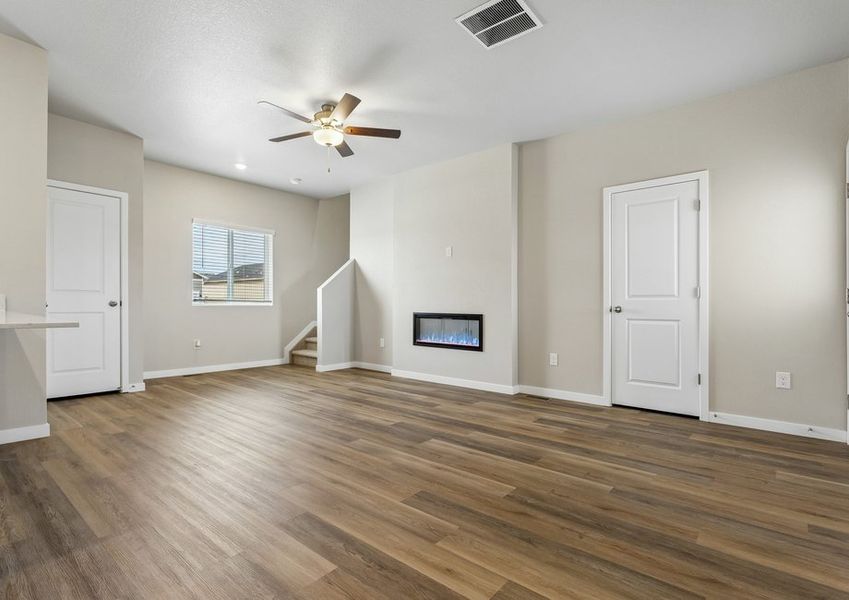 The family room is spacious with a ceiling fan and electric fireplace.