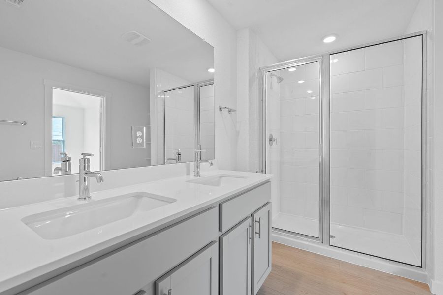 Full bath with a stall shower, double vanity, and light wood-style floors Full bath with a stall shower, double vanity, and light wood-style floors