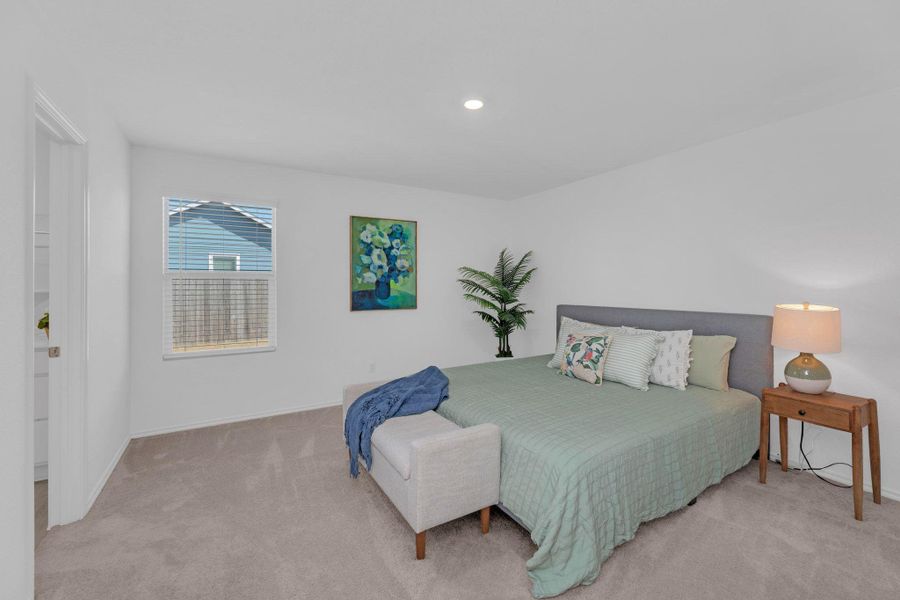 Spacious primary bedroom with natural light.