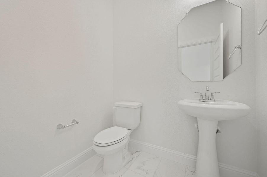 Bathroom featuring baseboards and marble look tile flooring