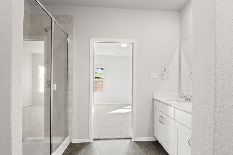Image of a primary bathroom with a standing walk-in shower and a jack and jill vanity