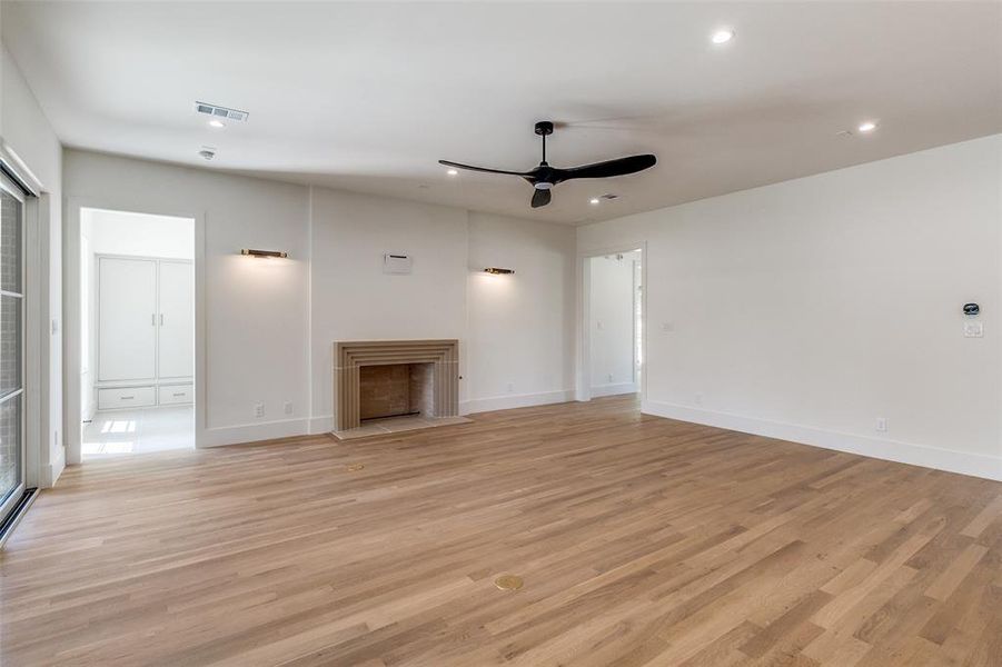 Unfurnished living room featuring recessed lighting, light wood-style flooring, a fireplace with flush hearth, and ceiling fan Unfurnished living room featuring recessed lighting, light wood-style flooring, a fireplace with flush hearth, and ceiling fan
