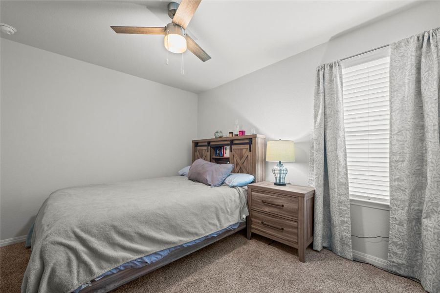A cozy bedroom with a ceiling fan offers comfortable living.