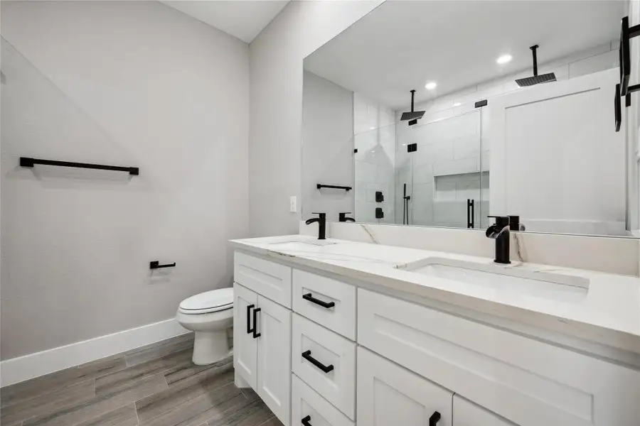 Primary bath has dual sinks, quartz countertops, upgraded faucets and fixtures and a large shower with dual rain heads.