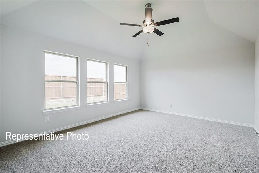 Carpeted spare room featuring ceiling fan and lofted ceiling