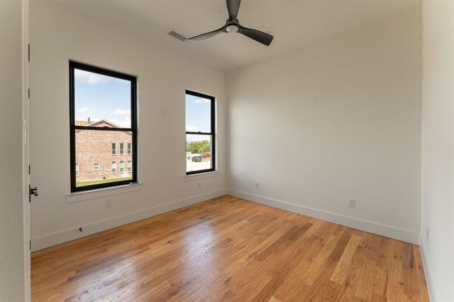 Empty room featuring light wood-style flooring and ceiling fan