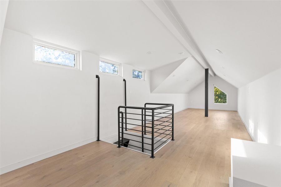 Additional living space with light wood finished floors and baseboards