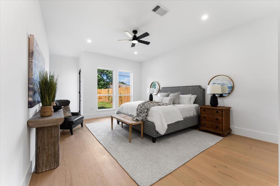 This spacious, bright primary bedroom features large windows and a private exit to the backyard. Neutral tones and modern decor create a calming atmosphere, enhanced by natural light and green views. This spacious, bright primary bedroom features large windows and a private exit to the backyard. Neutral tones and modern decor create a calming atmosphere, enhanced by natural light and green views.