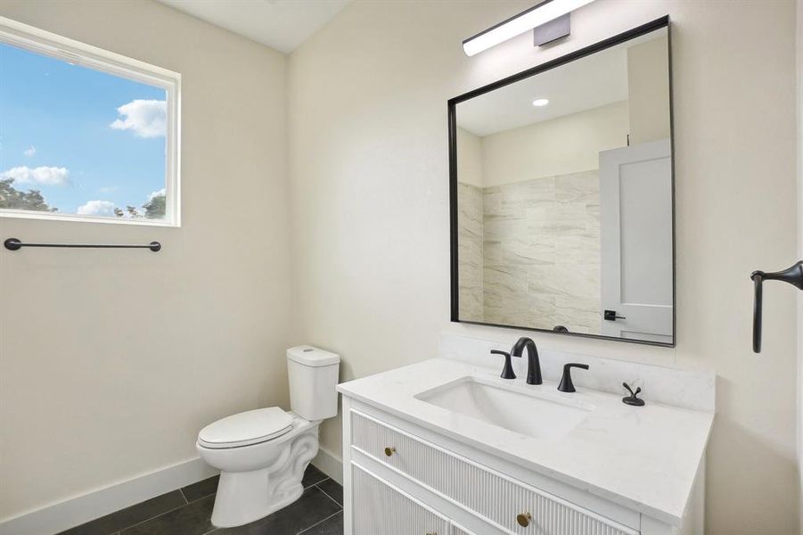 Bathroom featuring tile patterned flooring, vanity, and toilet