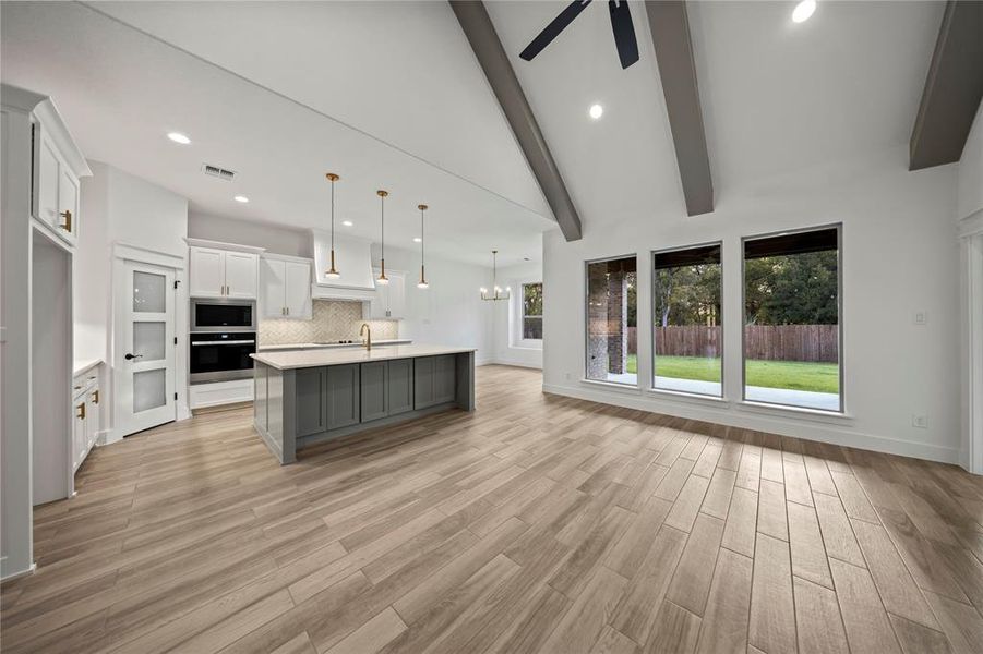 Kitchen with backsplash, white cabinetry, decorative light fixtures, stainless steel appliances, and recessed lighting