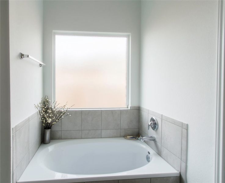 Elegant master bathroom offering a relaxing garden tub, separate shower, and a large walk-in closet—a perfect retreat within the home.
