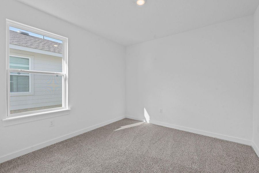 Spare room featuring carpet flooring and baseboards