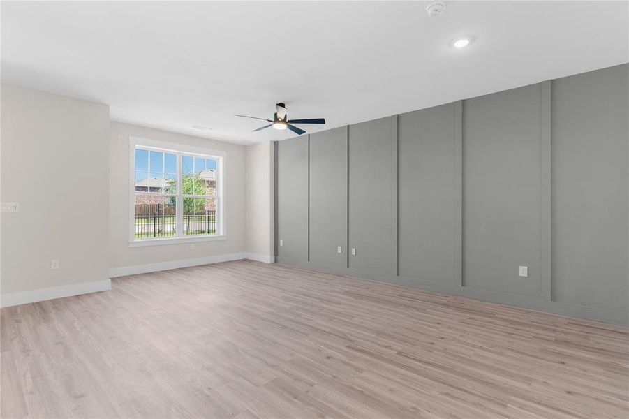Spacious interior featuring wood-finish flooring, a contemporary ceiling fan, and recessed lighting