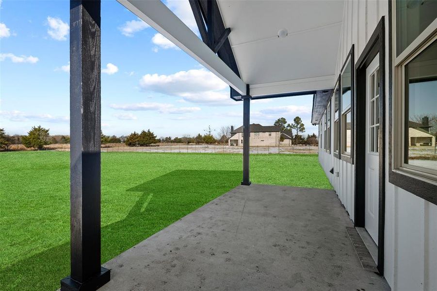 Expansive concrete patio with a white ceiling and dark wood-finish support beams Expansive concrete patio with a white ceiling and dark wood-finish support beams