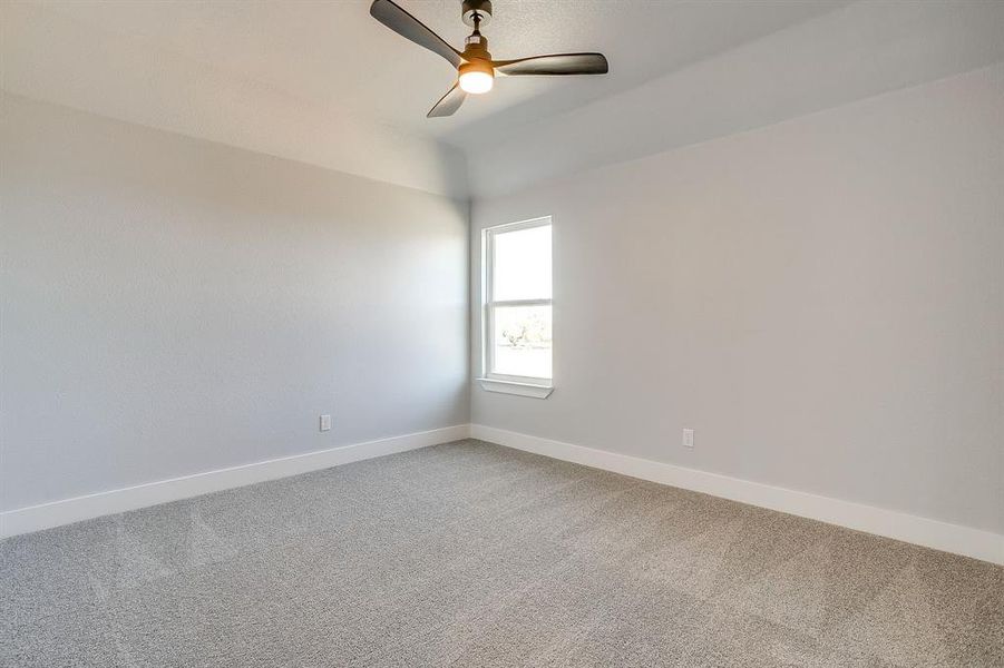 Spare room featuring carpet floors and ceiling fan