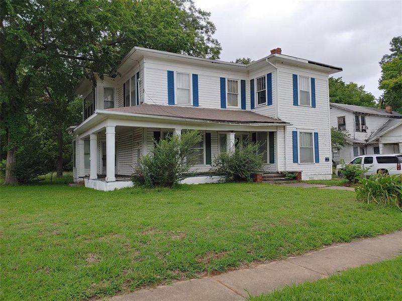 Two-story residence featuring white siding with contrasting blue shutters Two-story residence featuring white siding with contrasting blue shutters