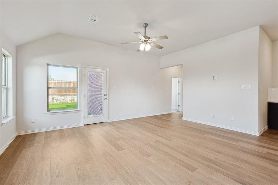 Spare room featuring ceiling fan, light hardwood / wood-style flooring, and lofted ceiling