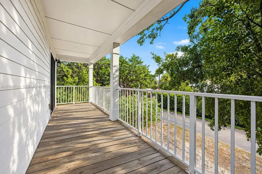 Covered deck featuring wood-finish decking, white metal railing, and white horizontal siding Covered deck featuring wood-finish decking, white metal railing, and white horizontal siding