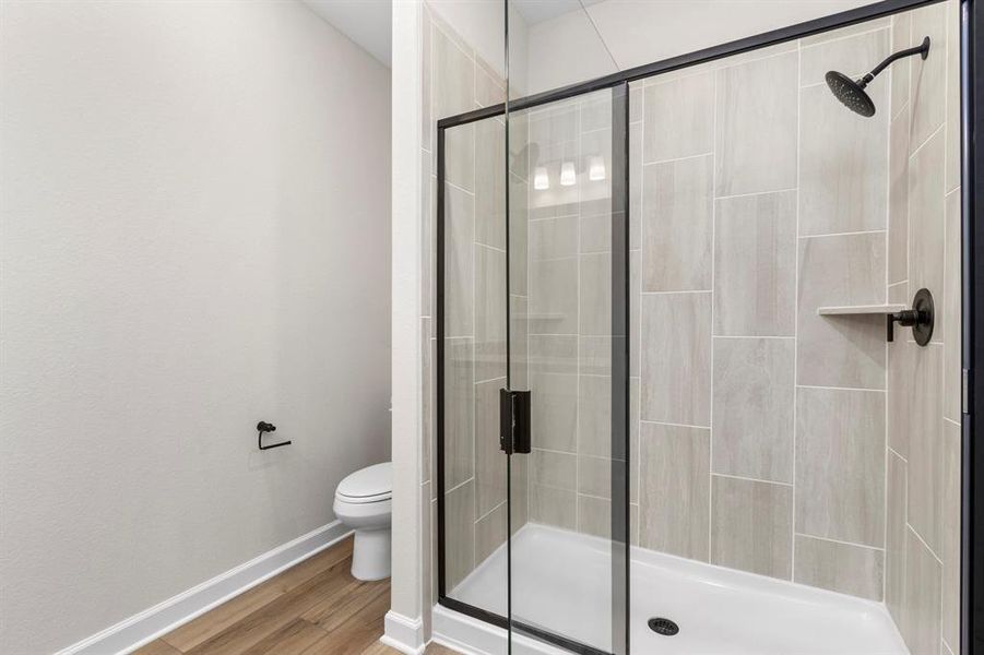 The primary bathroom has a large, standing shower and sleek tile.