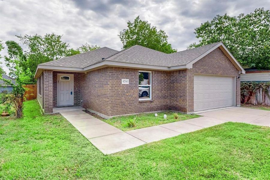 Single story home featuring a garage and a front yard