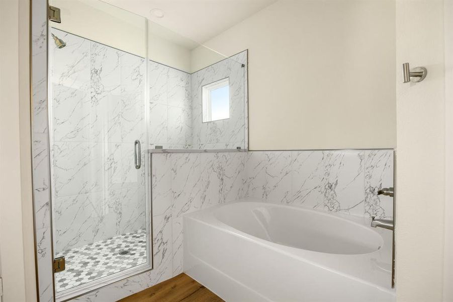 This additional view of the primary bath showcases a walk-in shower with tile surround and a separate garden tub perfect for soaking after a long day.