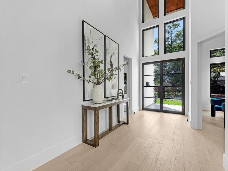 Another glimpse of the grand foyer, framed by expansive windows that bathe the home in natural light.