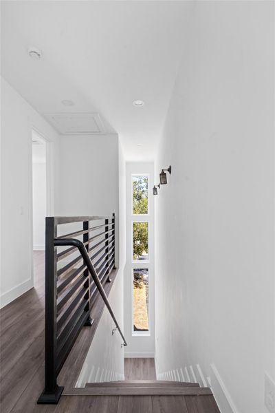 Stairway featuring wood finished floors, recessed lighting, and attic access Stairway featuring wood finished floors, recessed lighting, and attic access