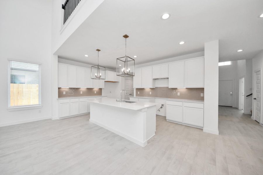 The kitchen is a culinary haven, featuring granite countertops, a tile backsplash, stainless steel appliances, 42” upper cabinets, and undercabinet lighting. Sample photo of completed home with similar floor plan. Actual colors and selections may vary. The kitchen is a culinary haven, featuring granite countertops, a tile backsplash, stainless steel appliances, 42” upper cabinets, and undercabinet lighting. Sample photo of completed home with similar floor plan. Actual colors and selections may vary.