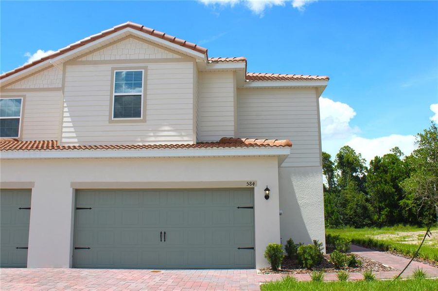 Front exterior of a new home in Noah Estates at Tuscany Preserve, Poinciana, FL, highlighting curb appeal (Image 1). Front exterior of a new home in Noah Estates at Tuscany Preserve, Poinciana, FL, highlighting curb appeal (Image 1).