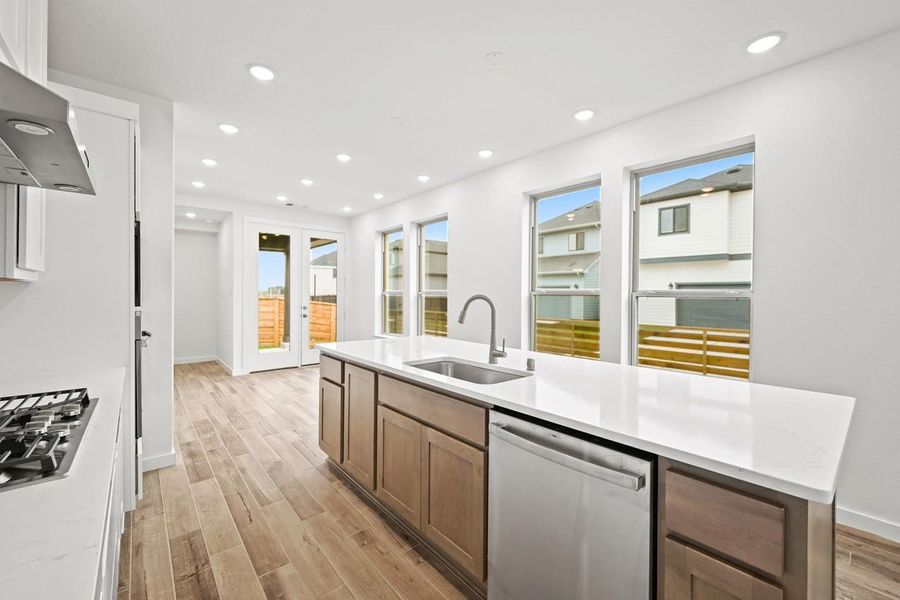 The kitchen is filled with natural light streaming through multiple windows, creating a bright and airy space for cooking and gathering. The kitchen is filled with natural light streaming through multiple windows, creating a bright and airy space for cooking and gathering.