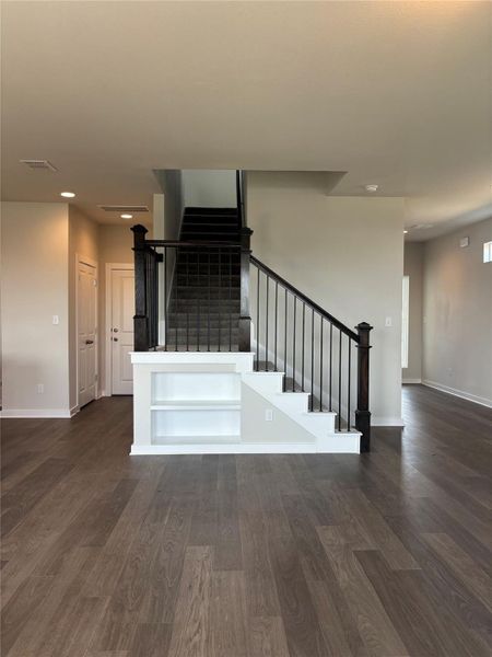 Staircase with wood finished floors and recessed lighting