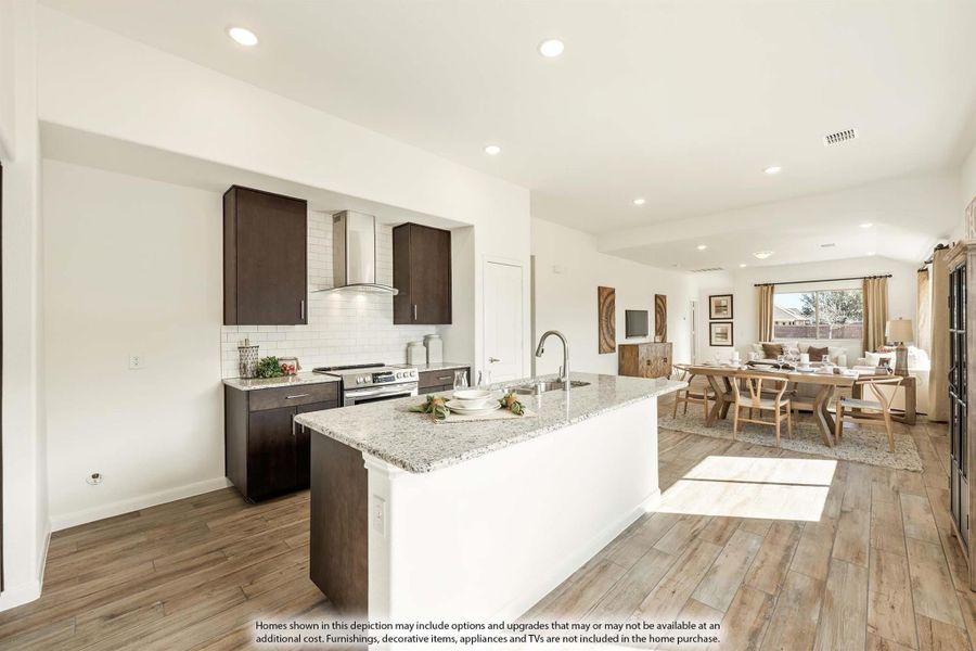 Open-concept kitchen with granite island, dark cabinets, and dining area on wood-look floors