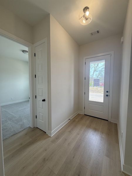 Doorway featuring baseboards and wood finished floors