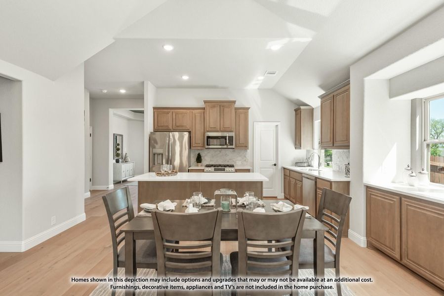 Open kitchen and dining area with wood cabinets, center island, stainless appliances, and six-seat dining table on light hardwood floors Open kitchen and dining area with wood cabinets, center island, stainless appliances, and six-seat dining table on light hardwood floors