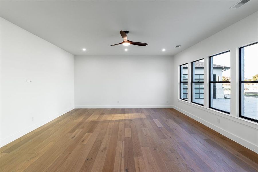 Empty room featuring ceiling fan and wood- flooring