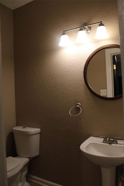 Bathroom with a textured wall and toilet Bathroom with a textured wall and toilet