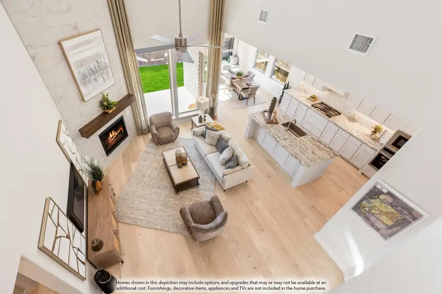 Open-concept living area with fireplace, kitchen island, and hardwood floors seen from above