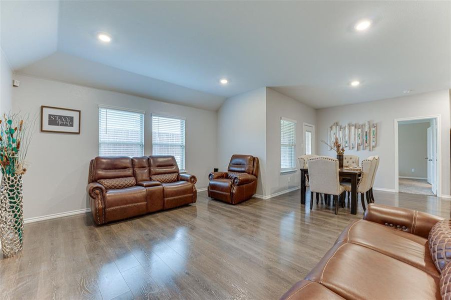 Living room with light hardwood / wood-style floors and vaulted ceiling