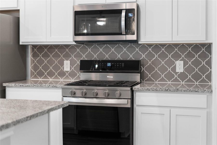 Showcased here is a Whirlpool gas range, paired with a steam microwave equipped with sensor cooking—all framed by an elegant tile backsplash. Showcased here is a Whirlpool gas range, paired with a steam microwave equipped with sensor cooking—all framed by an elegant tile backsplash.