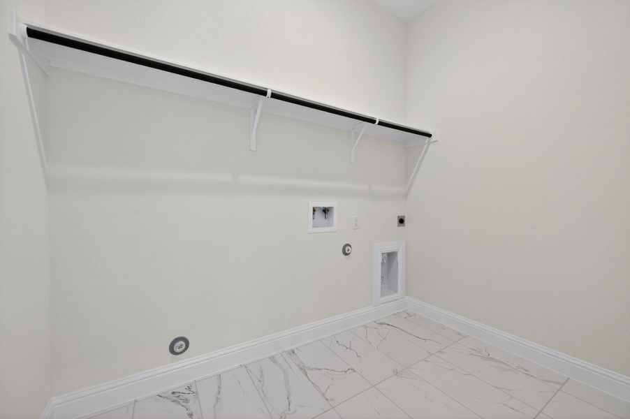 Washroom featuring gas dryer hookup, light marble finish floors, hookup for an electric dryer, and washer hookup