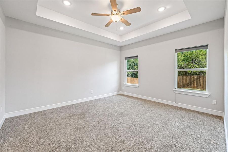 Unfurnished room featuring a tray ceiling, carpet floors, recessed lighting, and a ceiling fan Unfurnished room featuring a tray ceiling, carpet floors, recessed lighting, and a ceiling fan