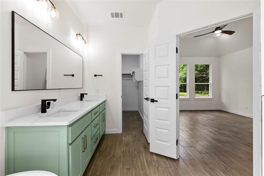 Dual vanity featuring mint green cabinetry, white countertops, and matte black fixtures