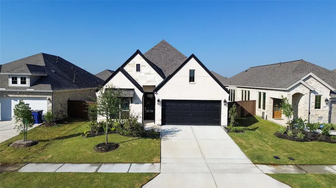 Front exterior of a new home in Meridiana 40'/45', Manvel, TX, highlighting curb appeal (Image 1).