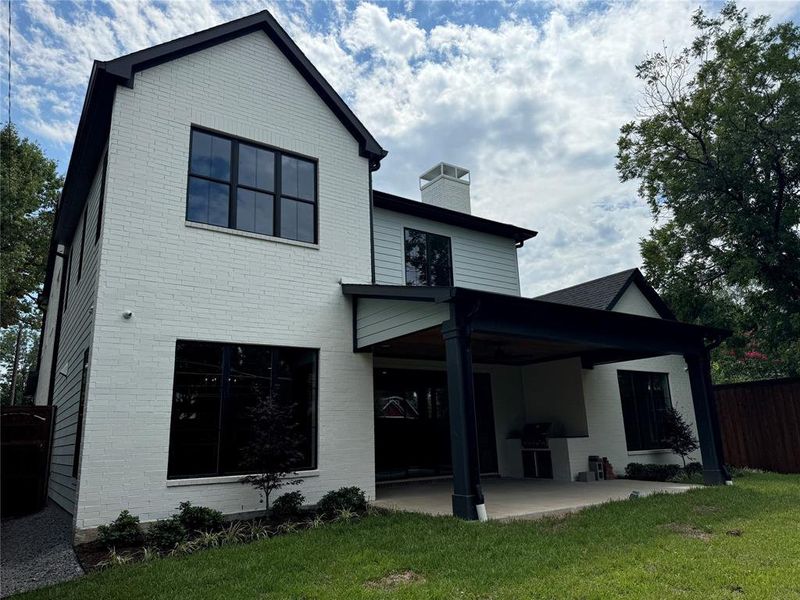 Back of house featuring a patio area and a lawn