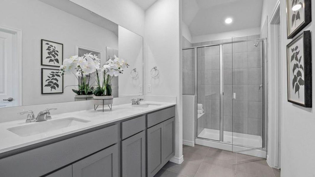 Full bathroom with double vanity, a shower stall, light tile patterned floors, and recessed lighting