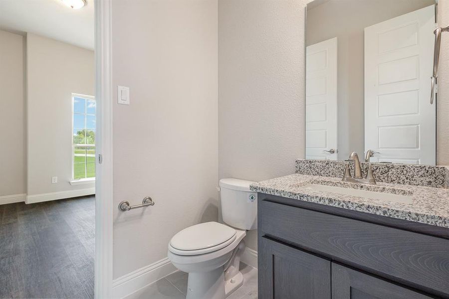 Bathroom with vanity, hardwood / wood-style floors, and toilet