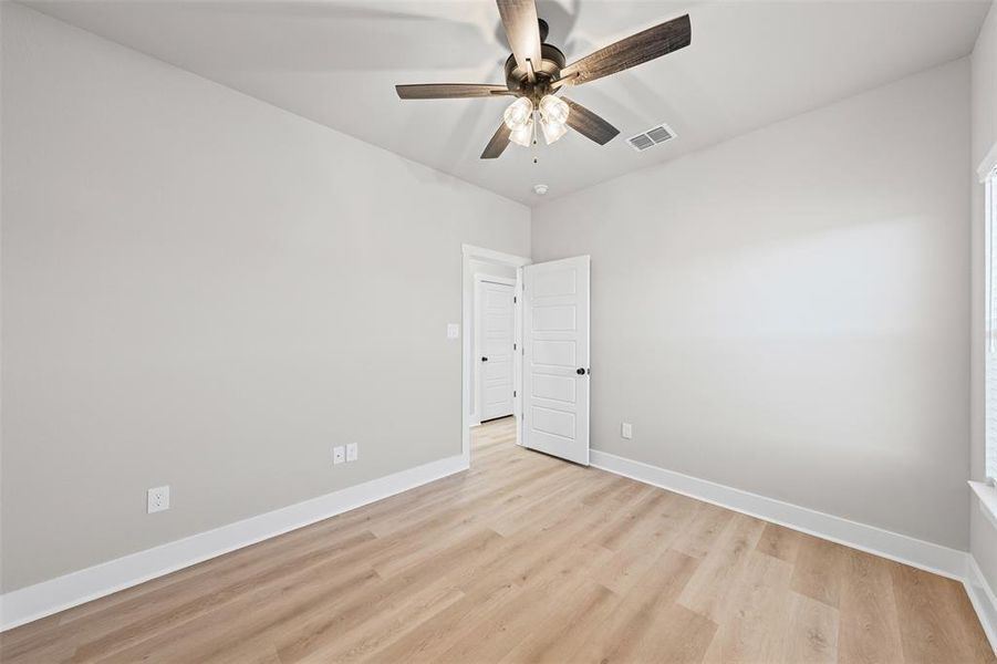 Empty room featuring light wood-type flooring and ceiling fan Empty room featuring light wood-type flooring and ceiling fan