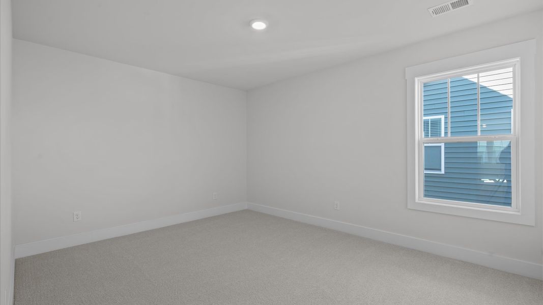 Elegant carpeted bedroom with walk-in closet and wall-to-wall windows offering natural brightness Elegant carpeted bedroom with walk-in closet and wall-to-wall windows offering natural brightness