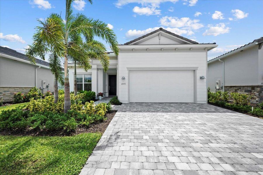 Front exterior of a new home in Avondale at Avenir, Palm Beach Gardens, FL, highlighting curb appeal (Image 1).